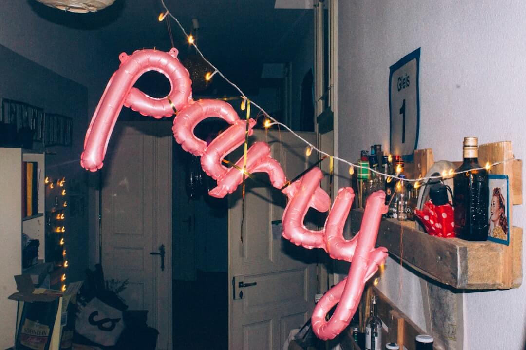 Ein pinker Luftballon mit der Aufschrift Party hängt an einer Schnur.